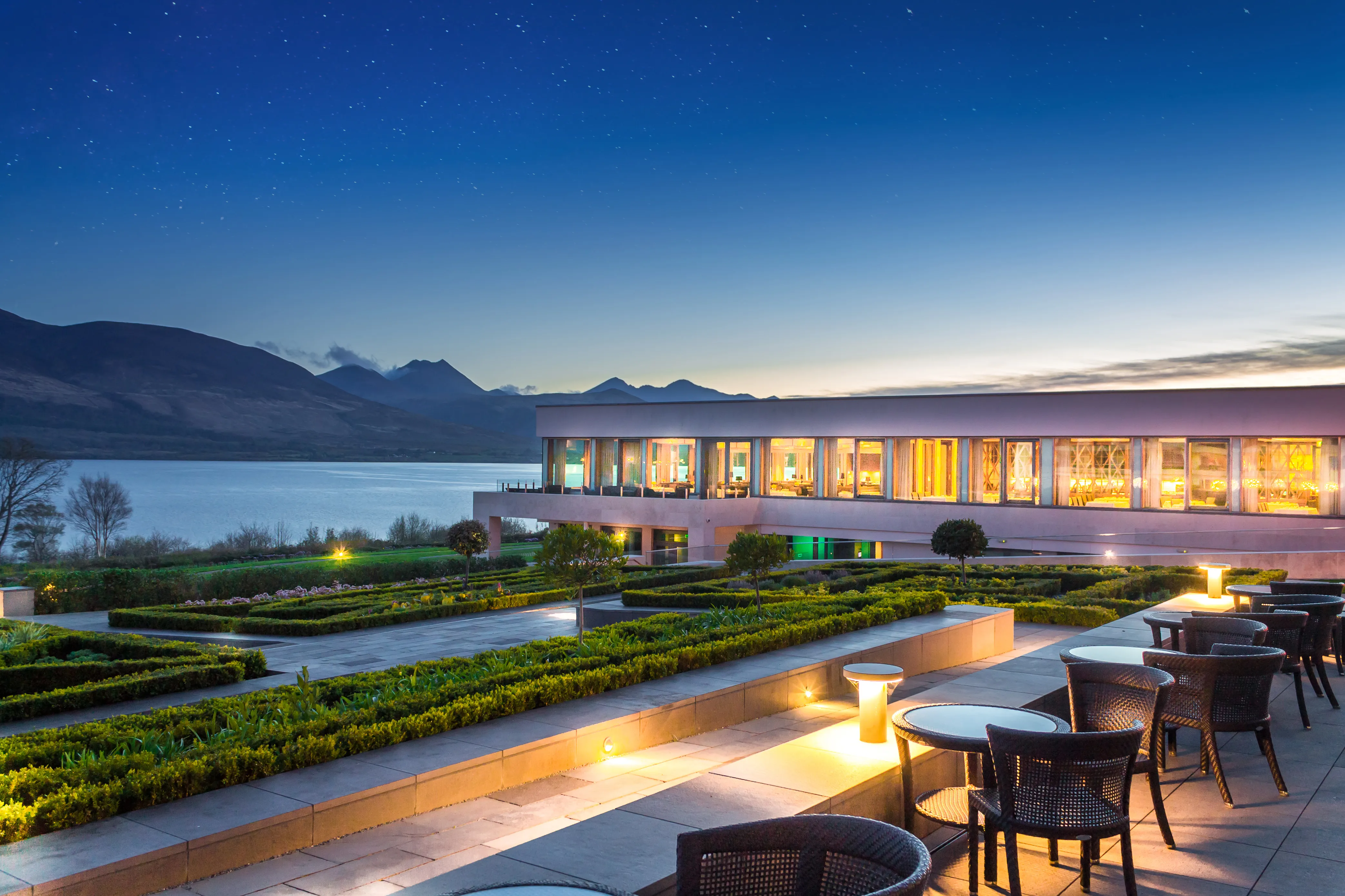 The Europe Hotel terrace at night with Lough Leane and mountain silhouettes lit by stars