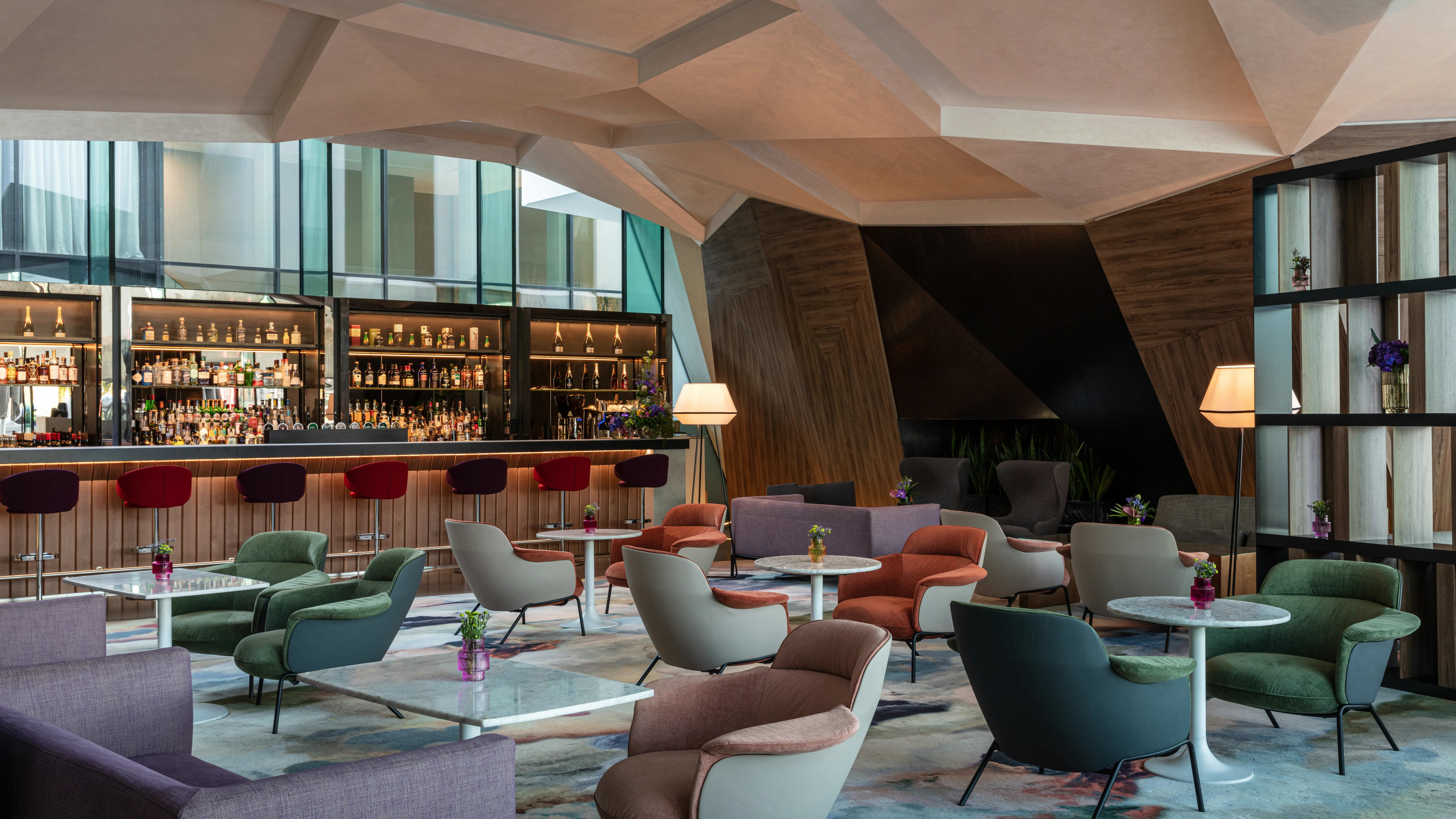 The Marker Hotel bar with geometric faceted ceiling and back-lit spirits wall