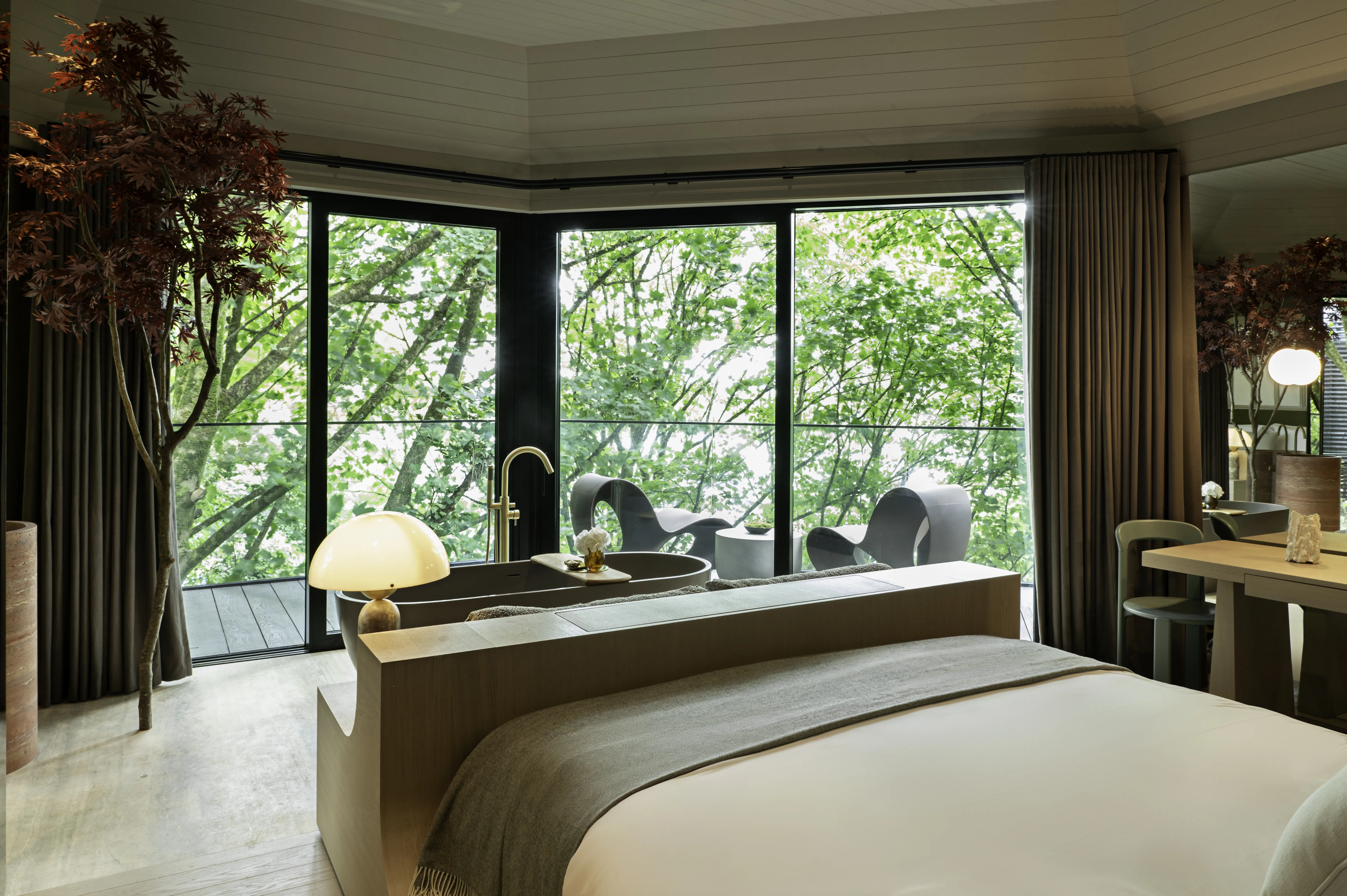 The Montenotte Woodland Suite bedroom with floor-to-ceiling forest views and sculptural bath