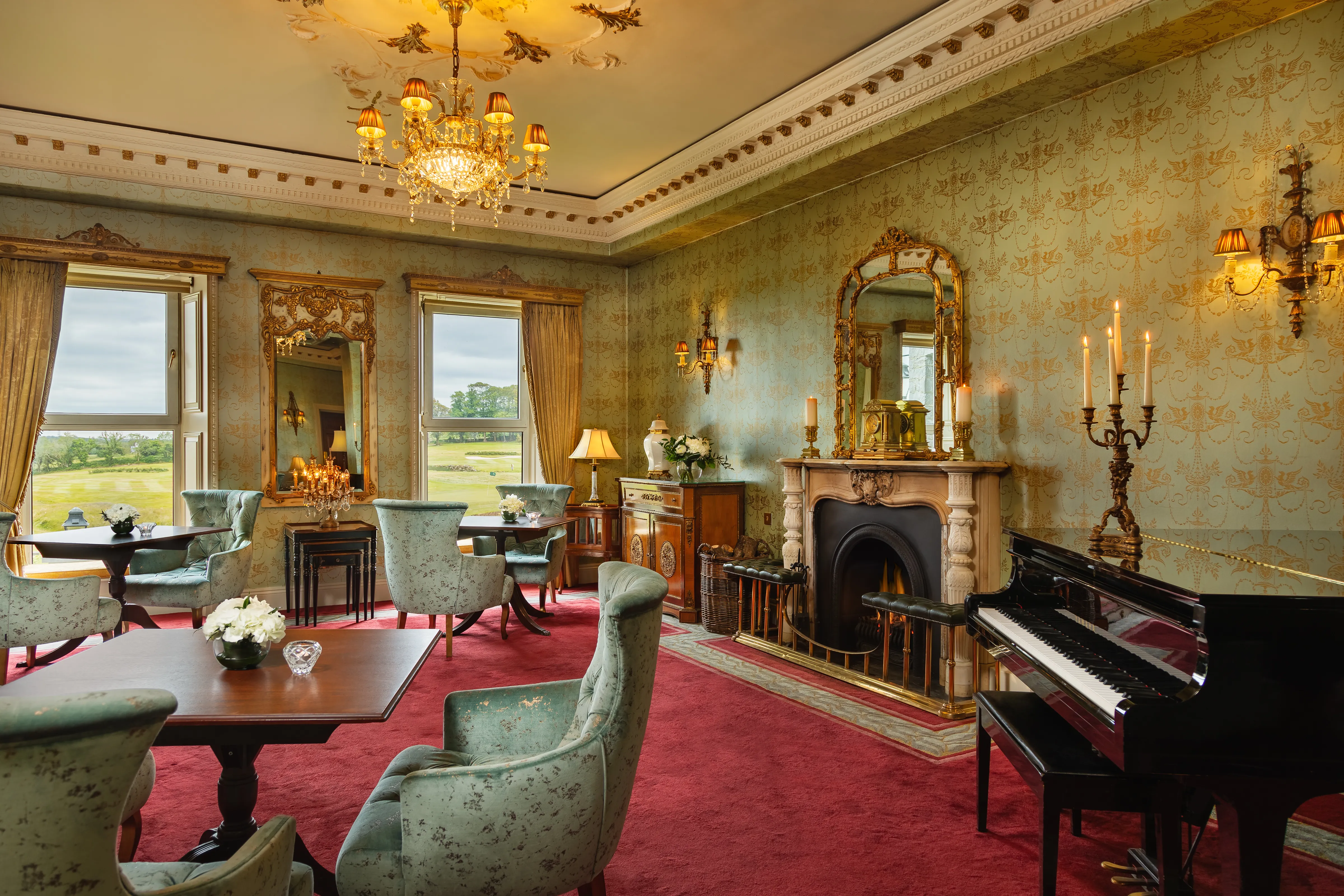 Glenlo Abbey French Room with gold plasterwork, baby grand piano and views to the parkland