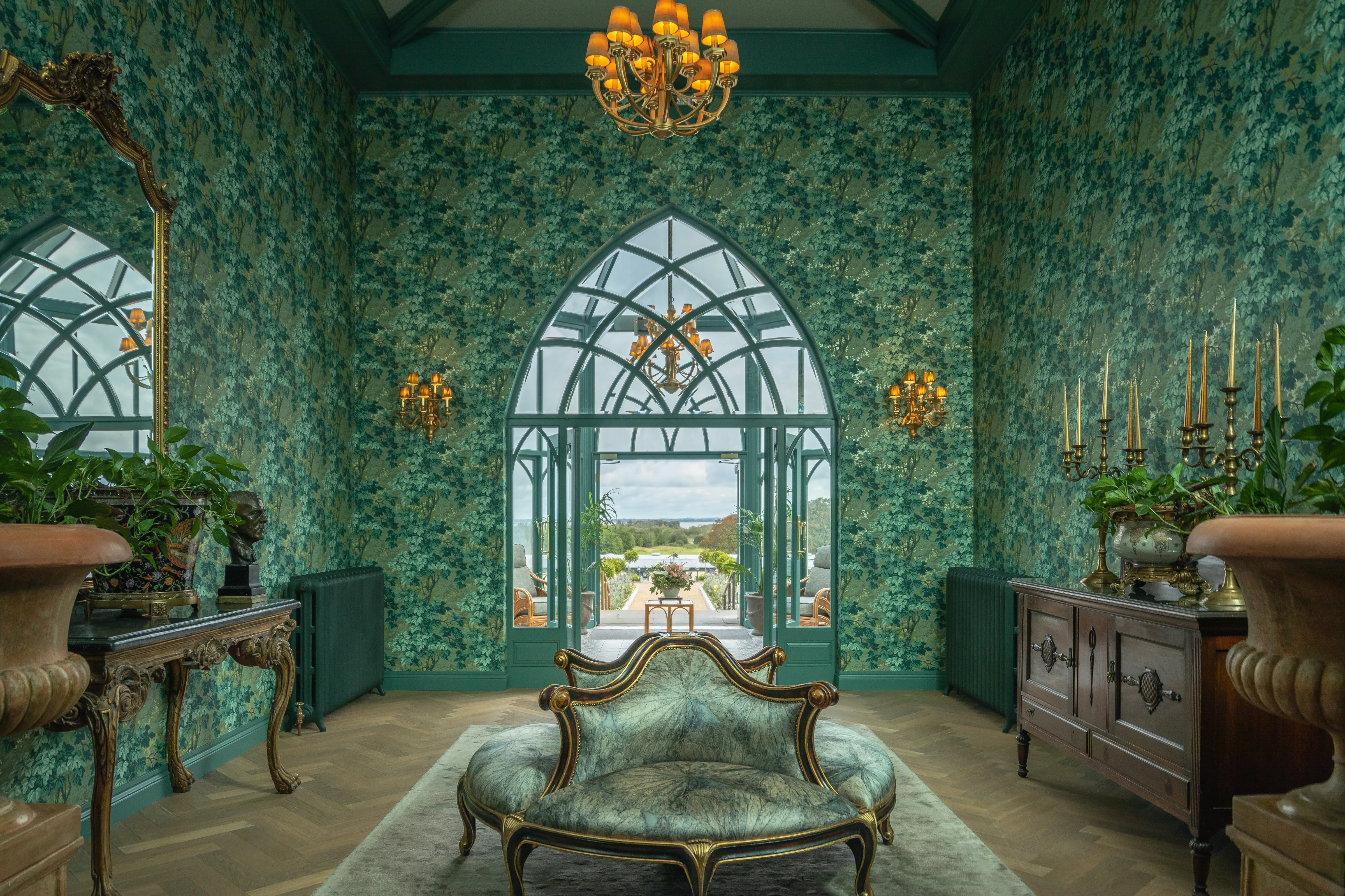 Glenlo Abbey Tapestry Room with emerald wallpaper, Gothic arch window and gold chaise longue